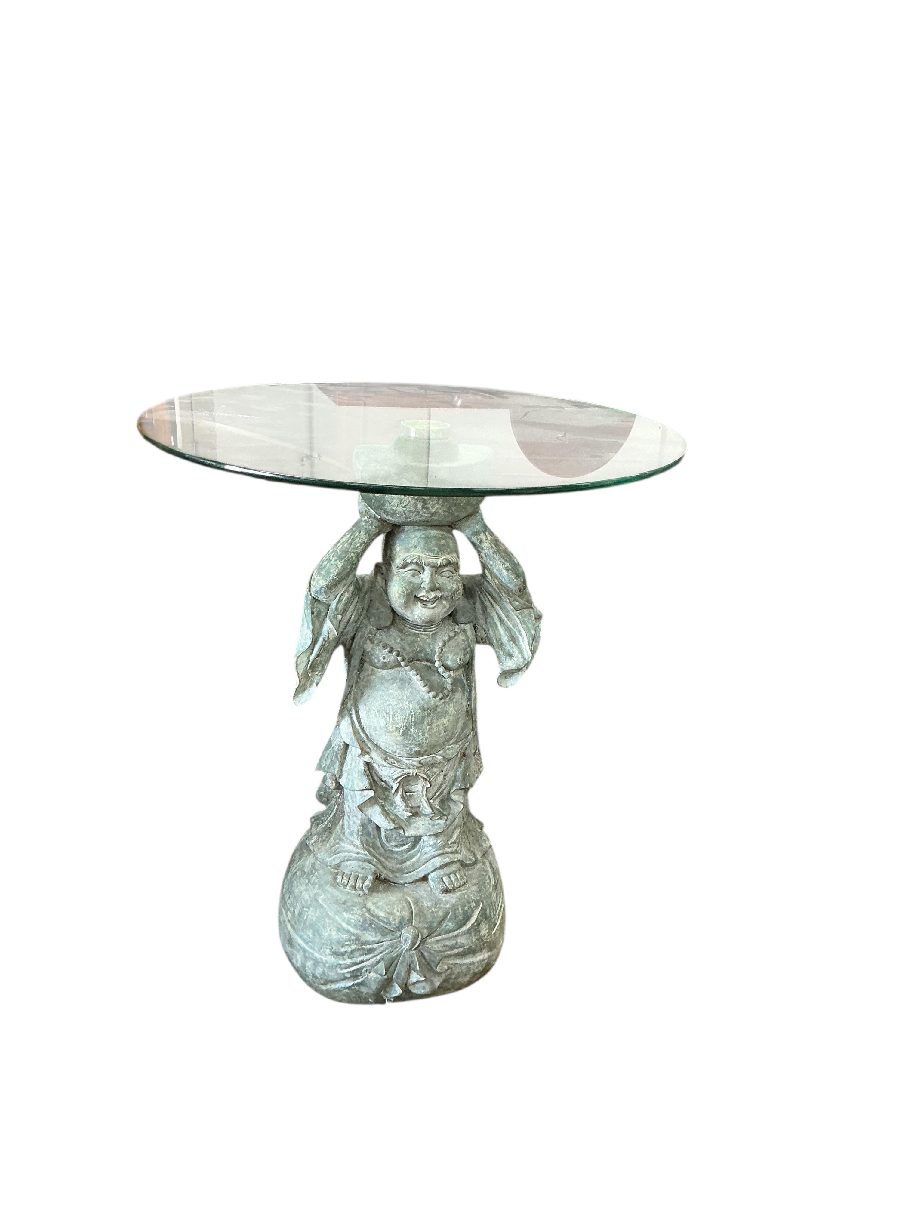 A pair of composition Buddha occasional tables with circular glass tops, diameter 51cm, height 60cm